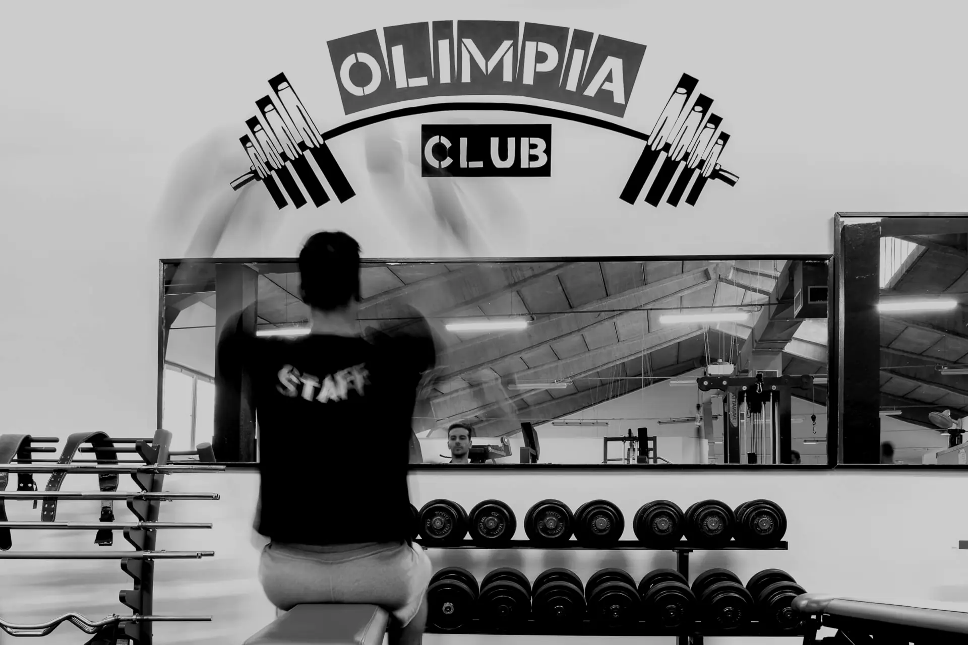 Allenamento in sala pesi con lo staff di Olimpia Club, davanti al logo della palestra